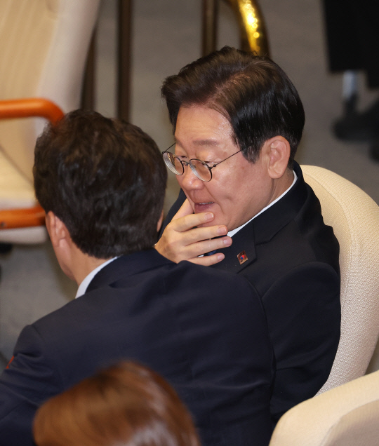 이재명 전 더불어민주당 대표와 김민석 의원이 30일 오전 국회 본회의에서 대화하고 있다.<연합뉴스>